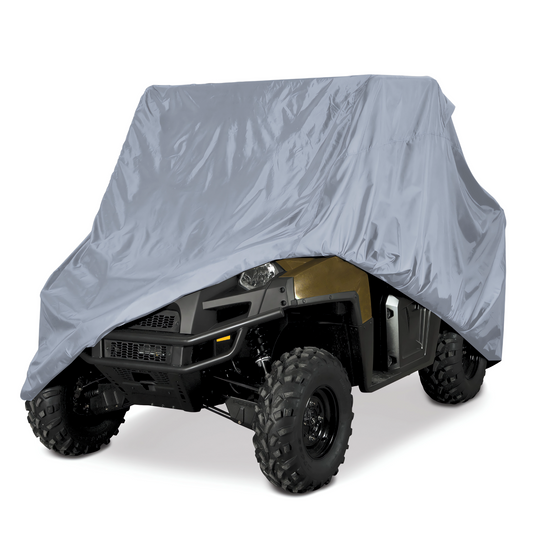 A large utility vehicle is partially covered by the Formosa Covers UTV Cover - Large 120" L x 62" W x 75"H, which is heavy-duty and water-repellent. The front wheels and part of the front bumper are visible, while the cover obscures the rest of the vehicle. Equipped with large, rugged tires, it is viewed from a front angle.