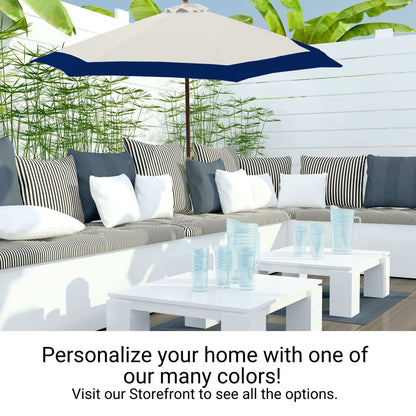 A modern outdoor patio features a white sectional sofa adorned with black and white striped and solid cushions. A large Formosa Covers 9ft Market Patio Umbrella with a 6 Rib Replacement Canopy in Duet Navy provides shade. Two white coffee tables display clear blue glassware. Text reads, "Personalize your home with one of our many colors!" and "Visit our Storefront to see all the options!