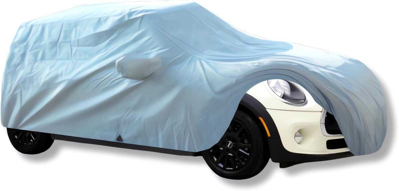 A Mini Cooper, clad in a Formosa Covers car cover designed for the Hardtop 2 Door and 4 Door, Convertible, and Coupe models up to 158"L, peeks through with its white bumper and black wheels visible. The heavy-duty cover is slightly transparent, subtly revealing the shape of the side mirror underneath.