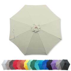 A large 9ft Market Patio Umbrella 8 Rib Replacement Canopy in Natural color, from Formosa Covers, is displayed fully open. Below it, a variety of 16 smaller umbrellas are arranged in a straight line, showcasing different colors including shades of red, yellow, green, blue, purple, black, and white. The durable polyester fabric ensures longevity.