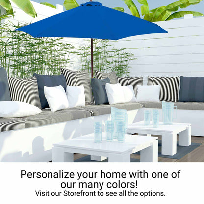 Outdoor patio scene featuring a white sectional sofa adorned with black-and-white striped and white cushions. A Formosa Covers 9ft Market Patio Umbrella with an 8 Rib Replacement Canopy in Cobalt Blue provides shade, and two white tables hold clear blue drinking glasses. Text invites you to "Personalize your home with one of our many colors!" and suggests visiting the storefront for more options.
