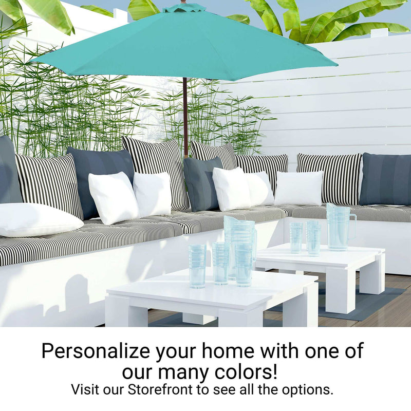 Outdoor patio area with a corner bench seat adorned with striped and solid cushions, a 9ft Market Patio Umbrella 8 Rib Replacement Canopy in Glacier Blue by Formosa Covers, a white table, and clear glasses. A message reads, "Personalize your home with one of our many colors!" followed by, "Visit our Storefront to see all the options.