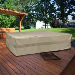 A large rectangular table on a wooden deck is covered with a Formosa Covers Patio Set Cover for Rectangular or Oval Tables, measuring 120