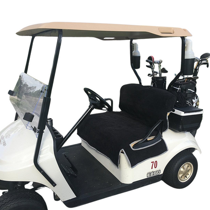 A well-maintained white golf cart featuring comfortable accessories, including a beige roof and clear windshield. It has two black cushioned seats with the Reversible Golf Cart Dual Seat Blanket Cover in black and taupe from Formosa Covers. The cart also includes a steering wheel, golf clubs stored in the back, and the number "70" printed on the side.