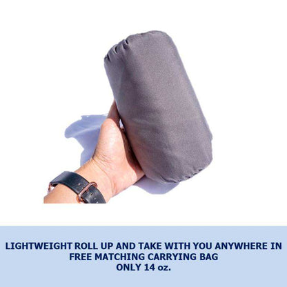 A person holding a rolled-up, gray, fabric item in their hand. The background is white, and there is a caption below: "Formosa Covers Sleeping Bag Liner Hiking Camping Hostel Travel Sack Sheet - Rectangular with Zipper 80"L. Easily roll up and take it with you anywhere in the free matching carrying bag. Only 14 oz.