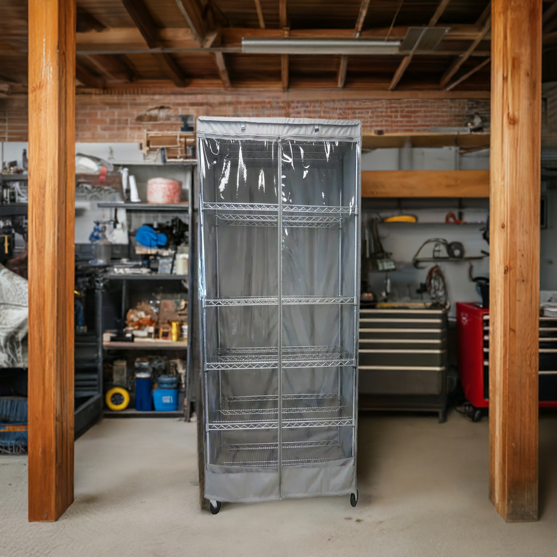 A Formosa Covers Storage Shelving Unit Cover, designed to fit racks measuring 24"W x 18"D x 72"H and featuring a gray, water-repellent zip-up cover with one see-through panel on the side, stands in the center of a workshop. The workshop includes various tools, storage boxes, and equipment organized on shelves and surfaces. Wooden beams and a partially exposed ceiling are visible.